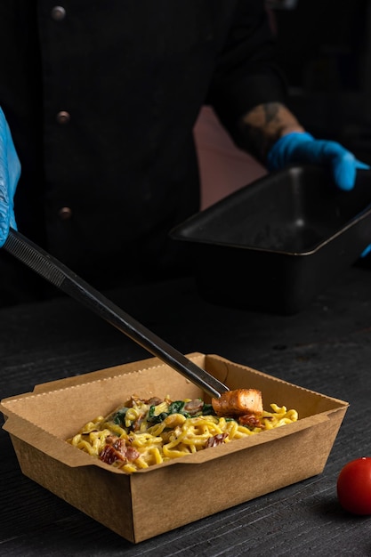 A man is cutting up a box of food from a food truck.