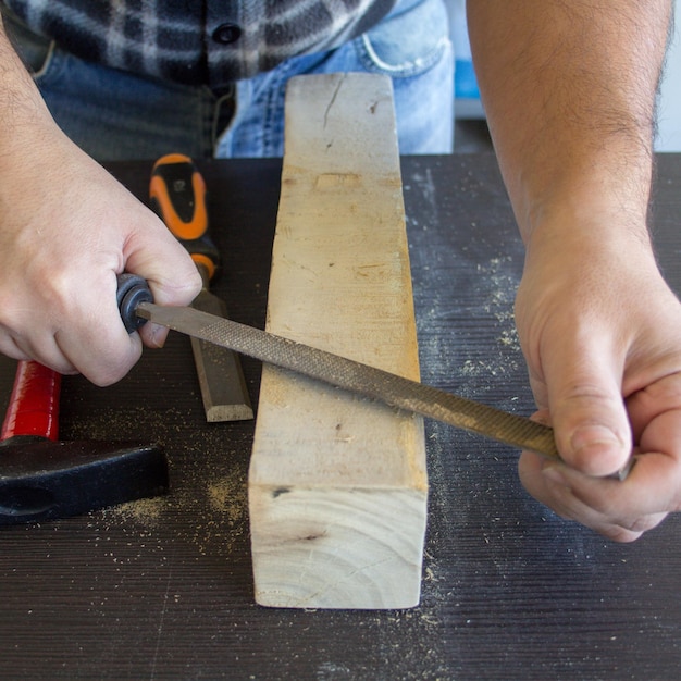 A man is cutting wood with a knife.