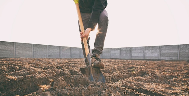 L'uomo sta scavando il terreno della sua casa di campagna