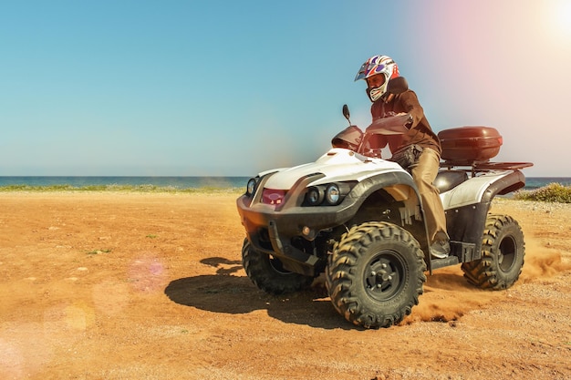 A man is driving ATV on offroad Sunny