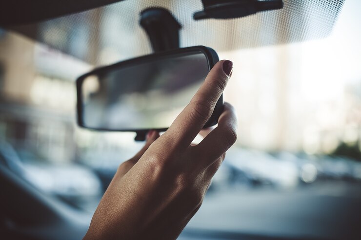 Photo a man is driving a rear-view mirror in the car