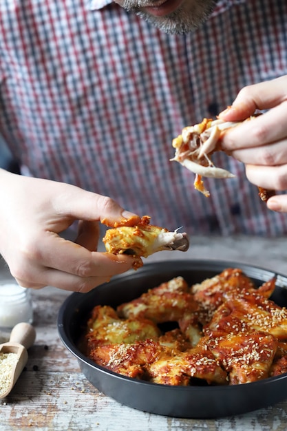 L'uomo mangia ali di pollo. ali di pollo fritto