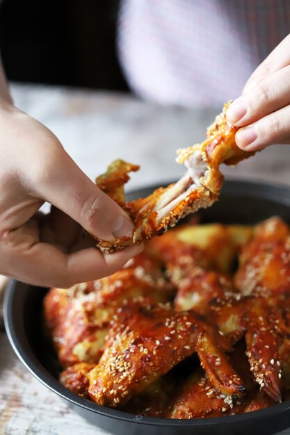 The man is eating chicken wings. Fried chicken wings.