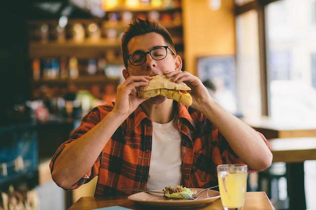 Man is eating in a restaurant and enjoying delicious food