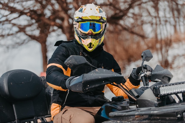 A man is fearlessly enjoying an adventurous ride on an atv quad through hazardous snowy terrain