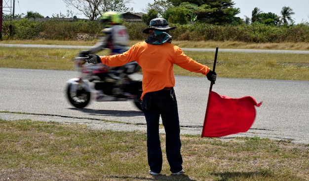 A man is flag for a harm signal in a motorcycle track