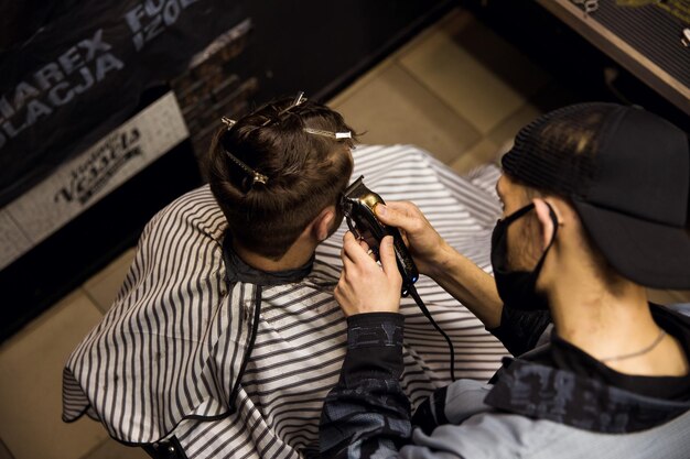 A man is getting a haircut by a barber