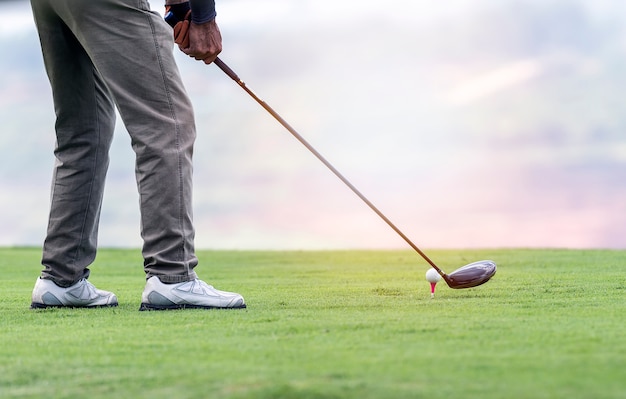 man is going to tee off with sunset