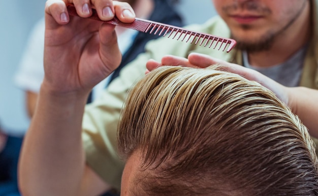 男が美容院でぶらぶらしている。理髪店でのヘアカットとスタイリング。ひげと髪の男性のケア。