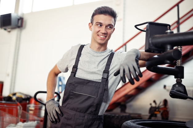 A man is at his work in a car repair service during a break.