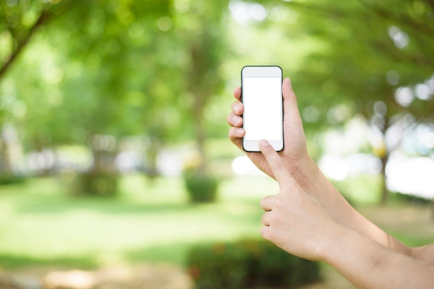 A man is holding cell phone on green