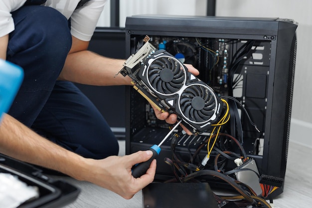 Photo man is holding a computer video card in his hands computer maintenance