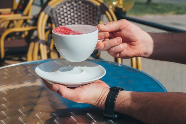 男がレストランで一杯のコーヒーを持っています。