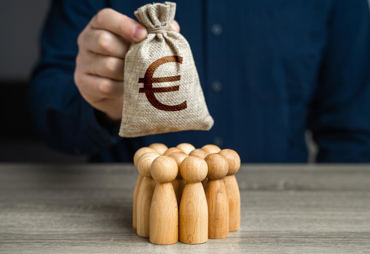 Photo a man is holding a euro money bag over a group of people figurines generation of funds from cooperation organization of the community budget payment for labor and services political lobbying