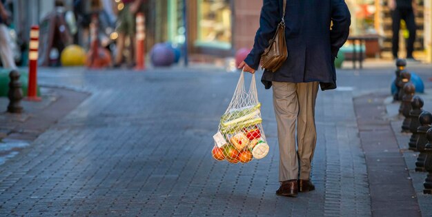 Man is holding mesh shopping bag