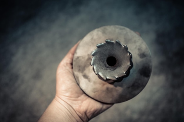 L'uomo tiene in mano un oggetto stampato su metallo d oggetto stampante stampato in macchina di sinterizzazione laser moderna d