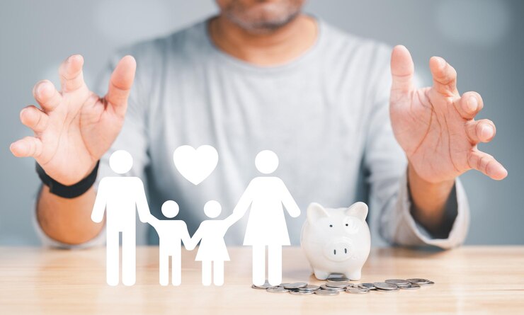 A man is holding a piggy bank and a family of four