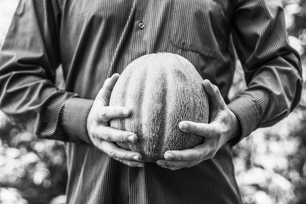 The man is holding a ripe melon, black and white photo