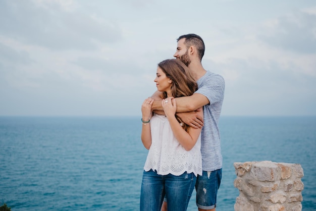 スペインの海の近くの高原公園で男がガールフレンドを抱きしめている