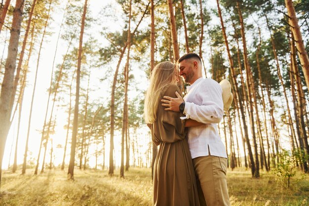 Man is in wit overhemd en vrouw in jurk Gelukkig stel is overdag buiten in het bos