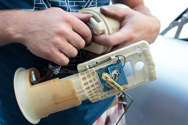 a man is independently repairing parts for a car replacing the gas pump at home with your own