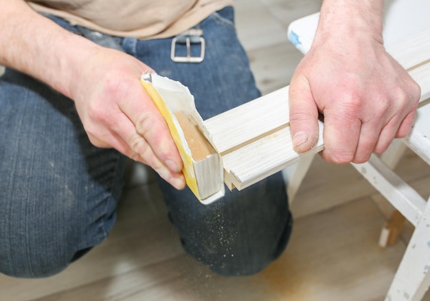 Foto l'uomo sta installando le porte falegname che tiene in mano un'asse di legno lavori di riparazione manutenzione nell'appartamento
