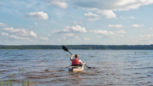 Photo a man is kayaking on a river on a bright sunny day