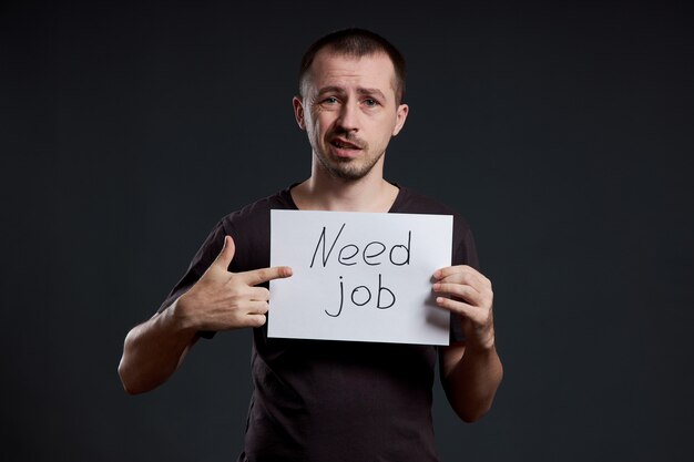 Photo man is looking for work, unemployment and crisis. different emotions on the face, a sign in the hands