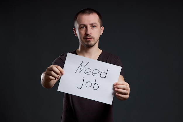 Man is looking for work, unemployment and crisis. Different emotions on the face, a sign in the hands