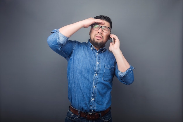 A man is making a phone call with a surprised expression.