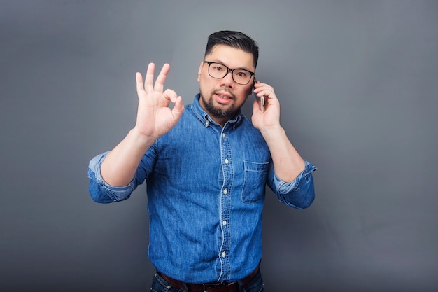 A man is making a phone call with a surprised expression.