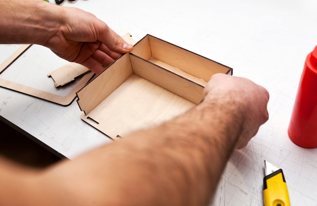 The man is making wooden box from the plywood