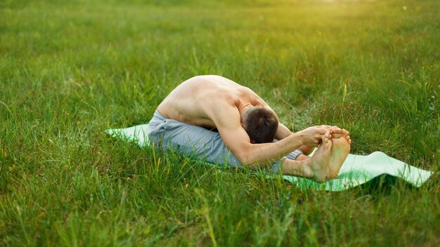 Man is making yoga in the park