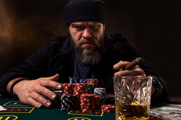 Man is playing poker. Emotional fail in game, game over for card player, man very angry with foolish choices, losing all the chips on bank. Concept of victory and loosing