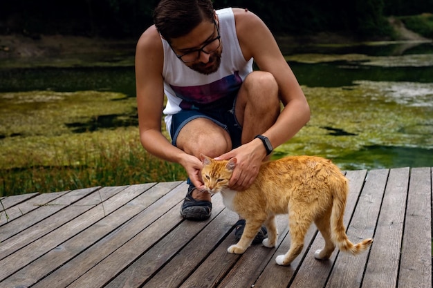 男は国産の赤いぶち猫と遊んでいます