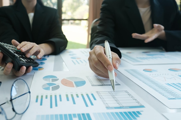 A man is pointing at a graph on a table while another man looks on