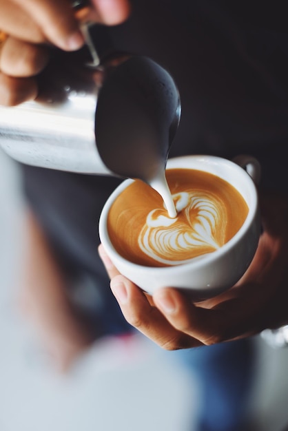 a man is pouring coffee into a cup of coffee.