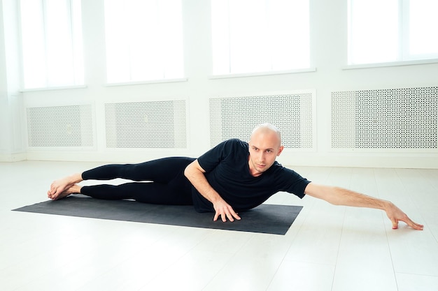 The man is practicing yoga in the studio. morning asanas in yoga class