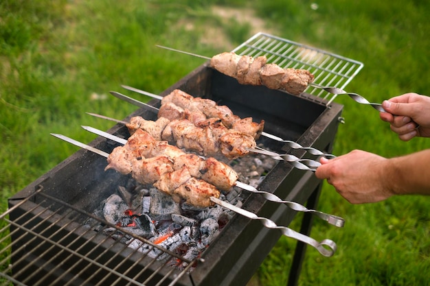 A man is preparing a barbecue in the yard