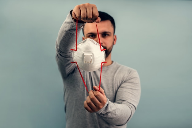 Un uomo indossa una maschera protettiva. protezione respiratoria dal coronavirus. dispositivi di protezione individuale per una pandemia di un'infezione virale. covid19.