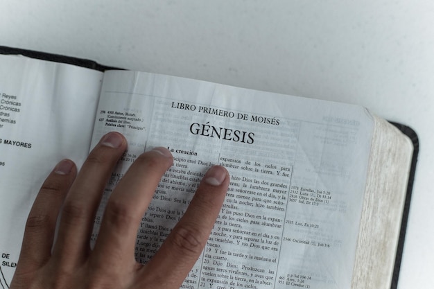 Photo a man is reading a bible with the word genesis on it