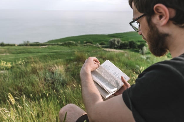 Man is reading a book outdoors