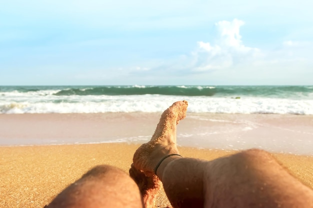 한 남자가 인도양 해양 배경의 모래 해변에서 휴식을 취하고 있다