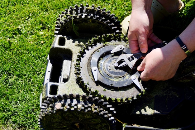 A man is repairing a chain that is part of a lawn care system.