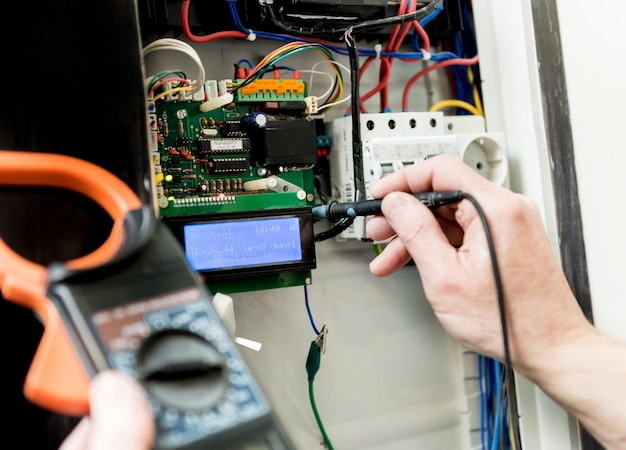 The man is repairing the switchboard voltage with automatic switches.