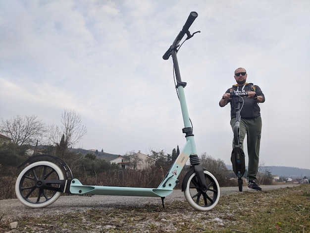 man is riding a regular scooter at city. Active life. Sport concept. Ecological type of transport