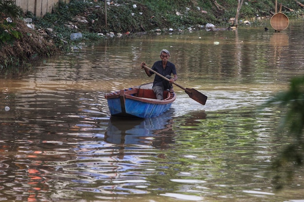 A man is rowing a boat with a paddle.