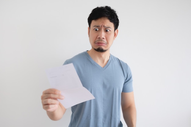 Man is sad and shocked by the letter in his hand on isolated background.