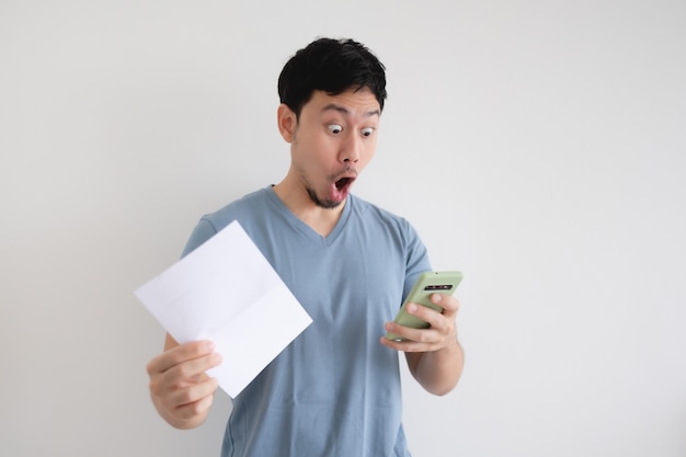 Man is shocked by the bill and the smartphone isolated.