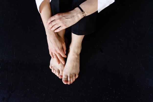 A man is sitting on a black floor Arms and legs